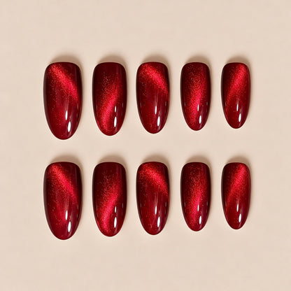 Our stunning red glass cat eye almond press-on nails bring a sophisticated, glamorous look. The rich ruby red cat eye finish creates a shiny light streak across each nail, perfect for date nights, parties, holiday & evening looks.
